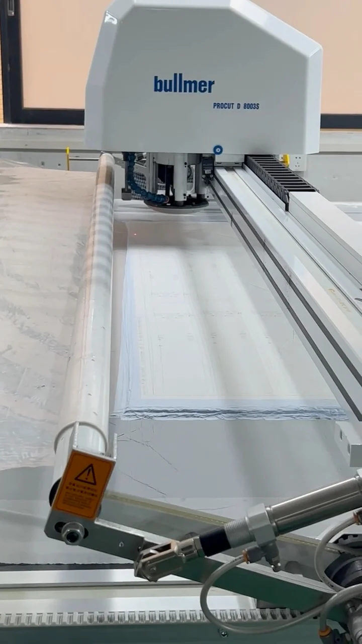 Machine head moving over fabric on a flat bed