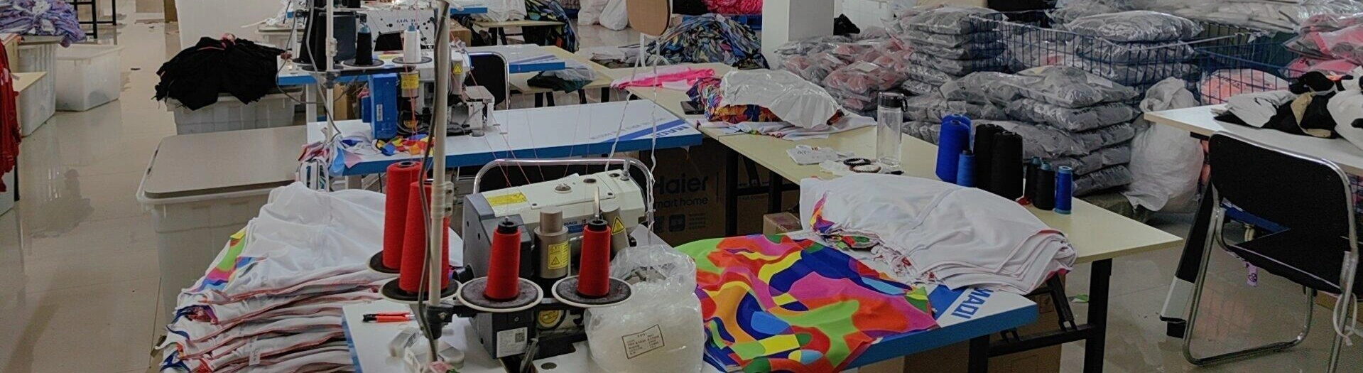 Sewing worktables with garment panels, thread and packed garments