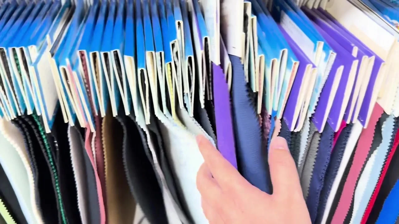 Hands browsing fabric swatch books in different colors