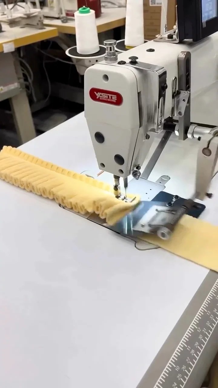 Yellow gathered fabric strip passing through a sewing machine
