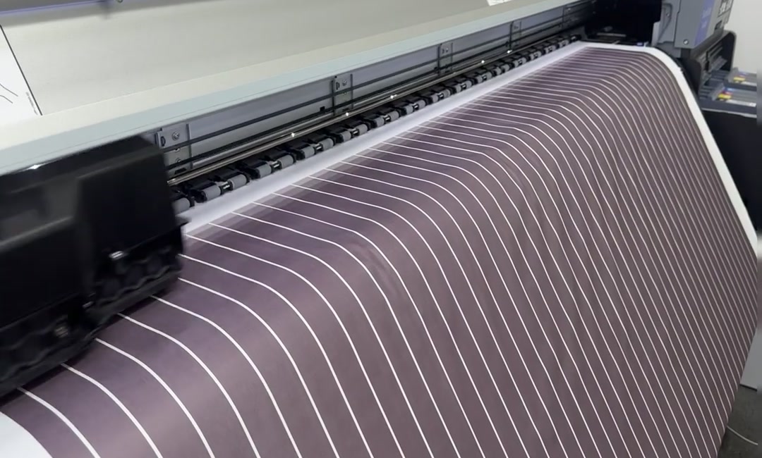 Striped material passing across a roller-fed work surface